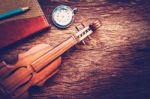 Violin And Notebook With Pencil On Grunge Dark Wood Background Stock Photo