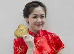 Asian Woman Holding Golden Heart Stock Photo