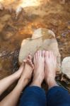 Feet Of Couple Sitting On The Stone Near River Stock Photo