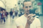 Young Man With Cell Phone Walking Stock Photo