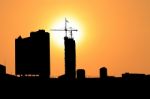 Sunset And Silhouette Construction City With Crane On Top Building Stock Photo