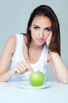 Upset Brunette Woman With Green Apple On A Plate Stock Photo