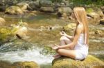 Woman Doing Yoga On Rock Stock Photo