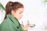 Woman Drinking Tea  At Home Covered With Blanket Stock Photo