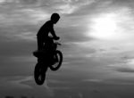 Motocross Rider Jumping Happily. While Floating In The Sky Like Stock Photo