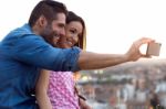 Young Couple Of Tourist In Town Using Mobile Phone Stock Photo