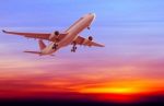 Commercial Airplane Flying At Sunset Stock Photo