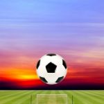 Soccer Ball With Soccer Field Against Beautiful Sunset Stock Photo