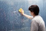 Woman Washes The Tile On The Wall With A Cloth Lather Stock Photo