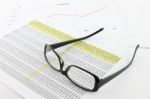 Eye glasses on financial report Stock Photo