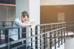 Tired Or Stressed Businessman Standing On The Walkway After Work Stock Photo