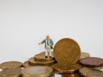 Miniature Businessman Stand On Euro Coins And Book Bank. Busines Stock Photo