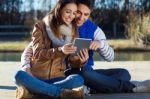 Outdoor Portrait Of Young Couple With Digital Tablet Stock Photo