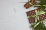 Polka Dot Gift With Christmas Decoration With Cinnamon And Pine Branches On White Wood Background Stock Photo