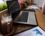 Coffee Cup  On A Table With Laptob And Graph Finance Diagram In Stock Photo