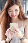 Portrait Of Thai Adult Beautiful Girl Using Her Smart Phone And Smile Stock Photo