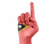 Flag Of Timor Leste ( East Timor ) On Pointing Up Hand Stock Photo