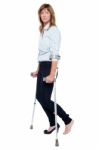 Pensive Looking Woman Using Crutches To Walk Stock Photo