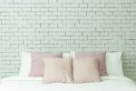 The Bed On White Bricks Wall Background Stock Photo