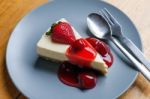 Strawberry Cheesecake With Spoon And Fork On Wooden Table Stock Photo