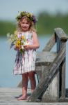 Little Seriously Looking Girl With Flowers Stock Photo