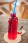 Red Syrup In The Bottle On Wooden Plate Stock Photo