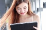 Portrait Of Thai Adult Beautiful Girl Using Her Tablet And Smile In University Stock Photo