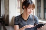 Portrait Of Thai Adult Beautiful Girl Using Her Tablet Stock Photo