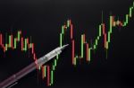 Stock Or Forex Graph Or Candlestick Chart And Pen On Black Screen Stock Photo