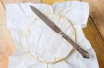 Camembert Cheese Wrapped In Paper With Vintage Knife On Wooden T Stock Photo