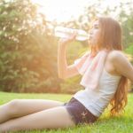 Woman Sitting Tired And Drinking Water After Exercise Stock Photo