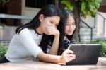 Two Asia Thai High School Student Best Friends Beautiful Girl Using Her Tablet And Funny Stock Photo