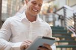 Smiling Man With Tablet Computer In Modern Business Building Stock Photo