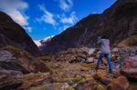 Younger Female Photographer Take A Photograph In Franz Josef Glacier Important Traveling Destination In South Island New Zealand Stock Photo