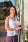 Girl Standing At Gate Outdoors Stock Photo