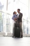 Loving Young Couple Embracing At Airport Stock Photo