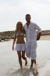 Young Couple Walking At Beach Stock Photo