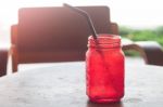 Iced Drink In Red Glass On Wooden Table Stock Photo