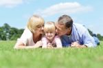 Parents Kissing Their Sweet Angel Stock Photo