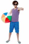 Cheerful Guy With Beach Ball Pointing At You Stock Photo