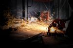 Worker Cutting Metal With Grinder. Sparks While Grinding Iron Stock Photo