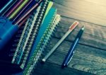 Heap Of Notebook With Pens On Wooden Table Stock Photo