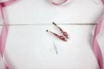 Golden Hairpins With Pink Gemstone And Pink Ribbon On White Wood Stock Photo