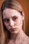 Girl With White And Pearl Rhinestones On Her Face Stock Photo