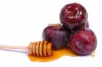 Violet Plums With Honey Dipper Stock Photo