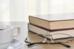 Book And Eyeglasses On A Wood Table Stock Photo