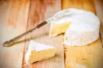 Camembert Cheese With Cut Wedge And Vintage Knife On Wooden Tabl Stock Photo