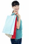 Girl With Shopping Bags Tossed Over Her Shoulders Stock Photo