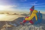 Young Woman Sitting On The Hill Of High Mountains Stock Photo