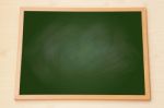 Blank Green Chalkboard With Wooden Frame On Wood Background Stock Photo